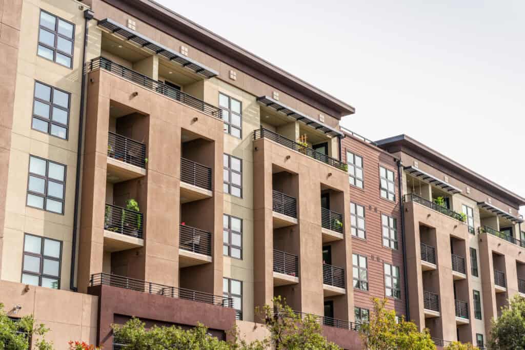 An image of a modern apartment building with balconies, showcasing junk removal and cleanout services for property management.