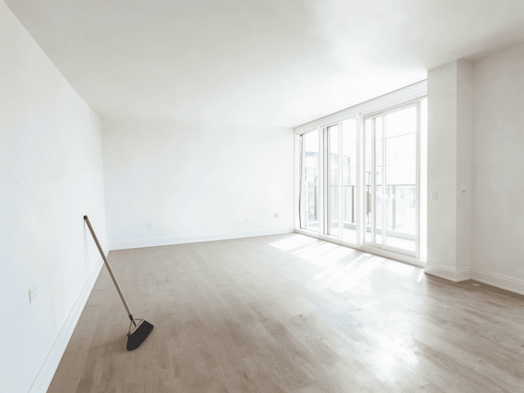 Empty living room with large windows and natural light, ready for junk removal or renovation.