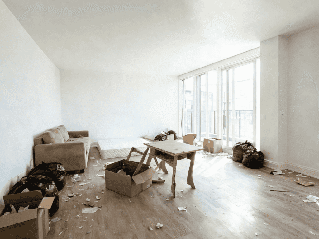 Empty living room with scattered trash and debris, awaiting professional junk removal services.