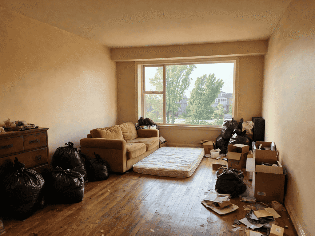 Interior room filled with trash bags, boxes, and debris ready for junk removal services.
