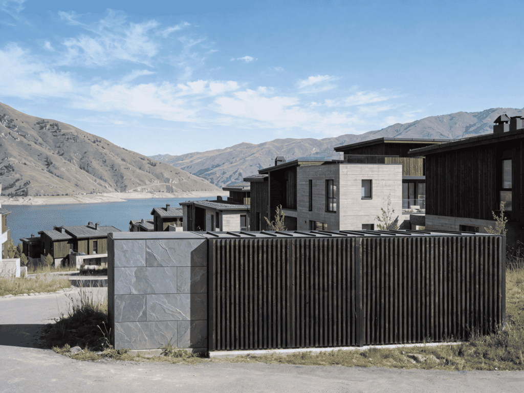 Contemporary houses with sleek designs and scenic mountain backdrop, showcasing modern architecture and outdoor fencing.