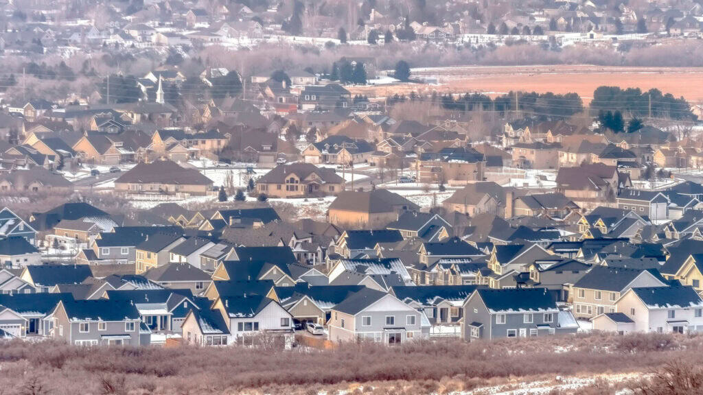 Aerial view of a suburban neighborhood showing a dense cluster of houses with varied rooftops.