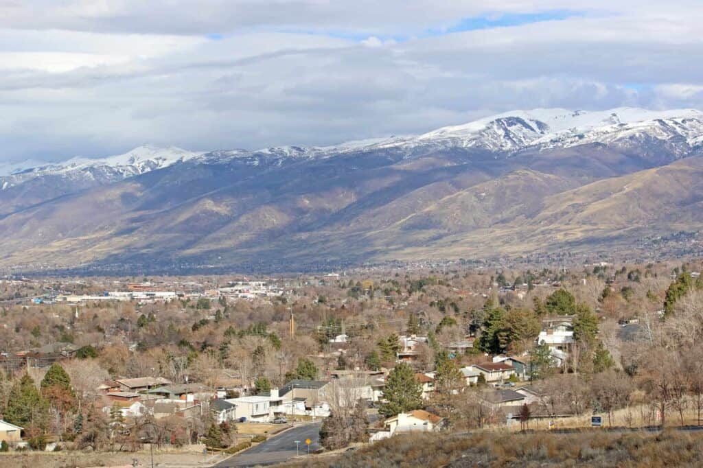 A scenic mountain view with snow-covered peaks and a rural town below, ideal for showcasing outdoor or landscape services.