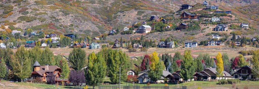 A picturesque hillside community featuring vibrant autumn foliage and cozy homes nestled among lush greenery.