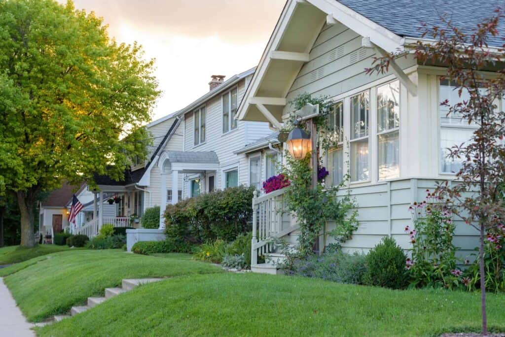 Beautiful suburban house with well-maintained lawn and colorful garden, showcasing a peaceful neighborhood setting.