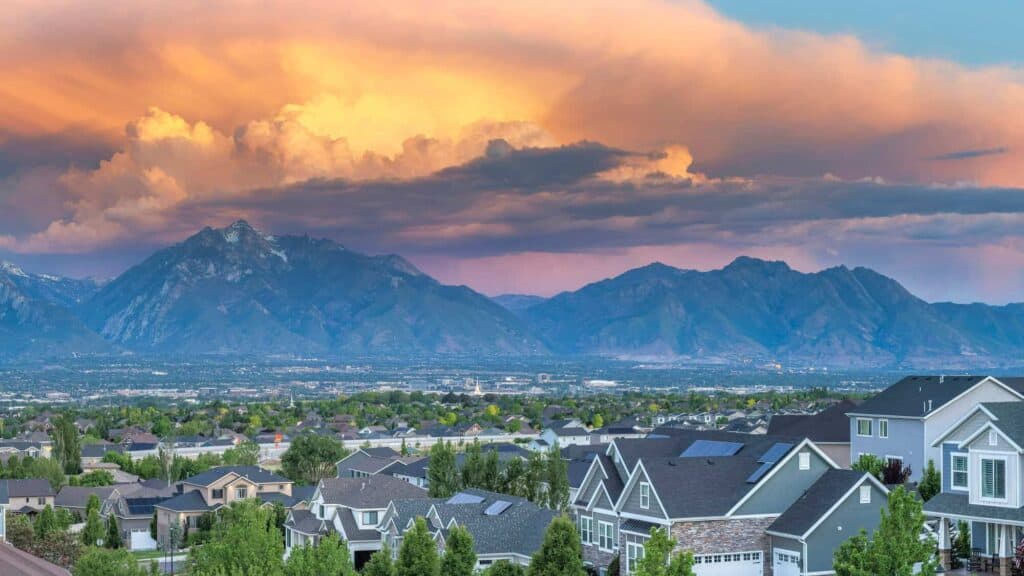 Scenic mountain landscape with a clear view over a peaceful suburban area during sunset. Perfect for illustrating property cl.