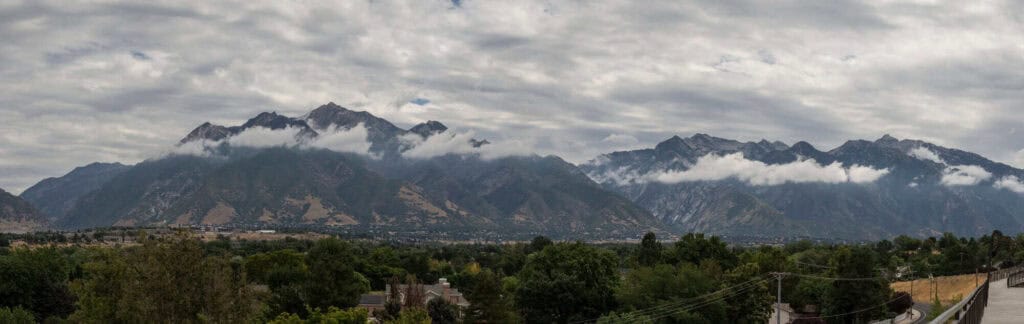 A scenic view of mountains with clouds and greenery, ideal for showcasing outdoor junk removal and cleanout services.