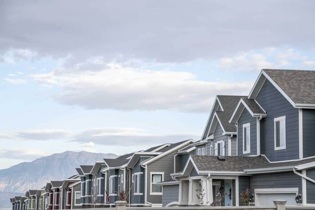 Row of modern suburban houses with mountain view in the background, showcasing clean and well-maintained properties.